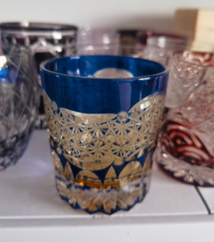 The intricate geometric carvings on the glass surface, through the contrast between the deep blue and the transparent glass, showcase a three-dimensional effect under the refraction of light and shadow