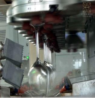 Automated production and quality inspection line for stemmed glasses The wine glasses, neatly arranged on an automated industrial production line, are undergoing processing and quality inspection, showcasing advanced modern manufacturing technology.