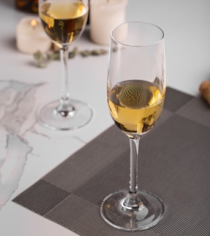 A flute-shaped stemmed glass holding golden champagne, product visual image from a slightly downward angle.