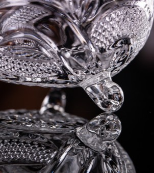 A close-up of the three-legged support of the crystal glass candy jar showcases its sturdy support structure and smooth polished details.