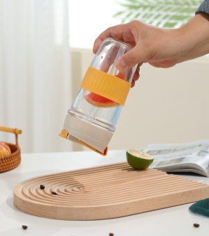 Holding an upside-down Xinghuo Glass travel mug filled with fruit juice, showcasing its 360-degree leak-proof design
