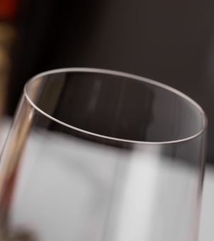 A close-up of the laser-cut rim of a Xinghuo Glass crystal cup, showcasing its thin, rimless design.