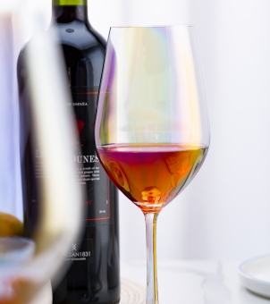 Xinghuo Glass iridescent crystal goblet with red wine refracting golden and purple light