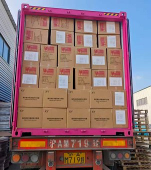The rear door of the pink container truck opened, revealing neatly arranged containers filled with Xinghuo Glass export cartons.