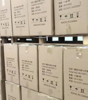 Export cartons stacked on wooden pallets in Xinghuo Glass's warehouse are wrapped with transparent moisture-proof protective film.