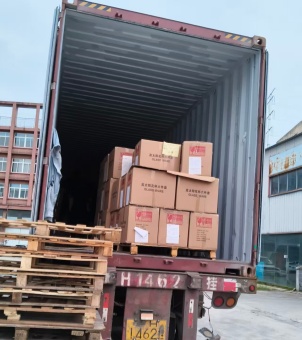 Xinghuo Glass's custom-made glassware boxes, complete with wooden trays, are being loaded into a container truck.