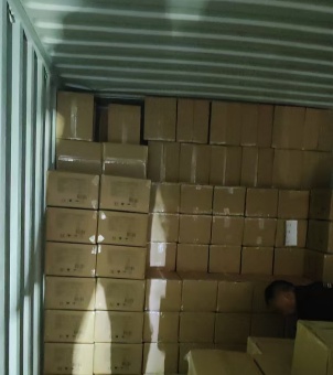 Xinghuo Glass workers are stacking cardboard boxes of glassware destined for Italy inside a shipping container.