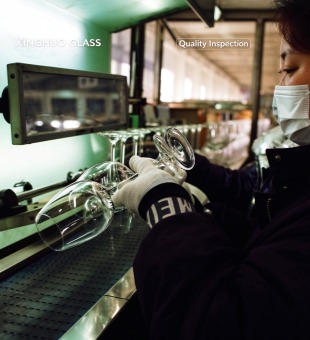 The quality inspector checks each glass individually on a backlit inspection table (looking for bubbles, scratches, and thickness)
