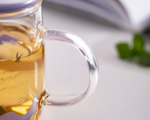 Close-up images of the handle and body of the Xinghuo glass printed glass mug with lid.