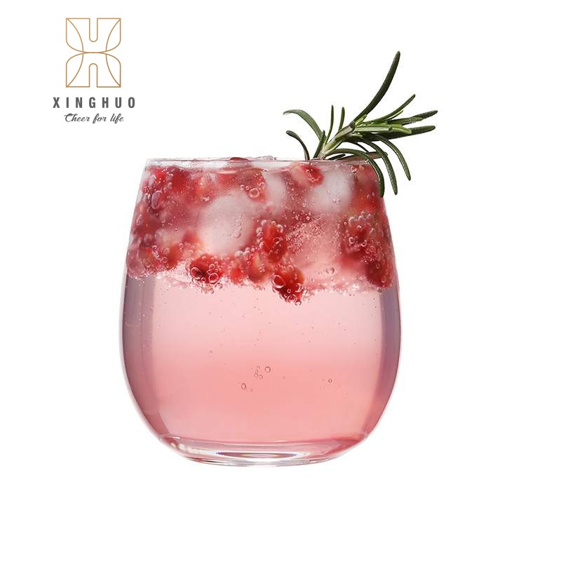 A close-up of the egg-shaped glass containing the pink pomegranate cocktail.