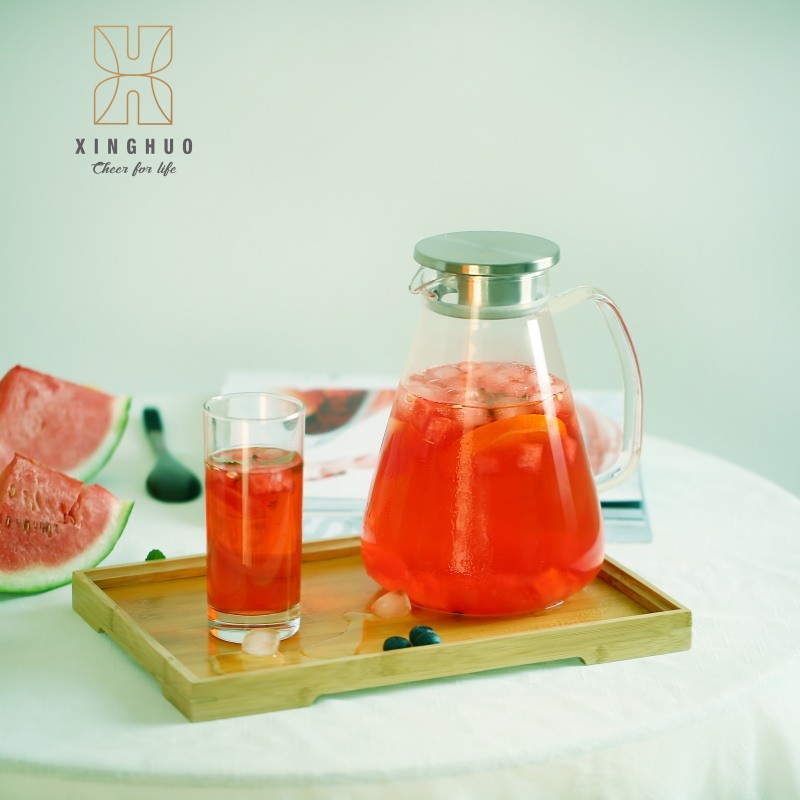 Image of a heat-resistant glass pitcher and glass holding watermelon and cold drinks on a bamboo tray.